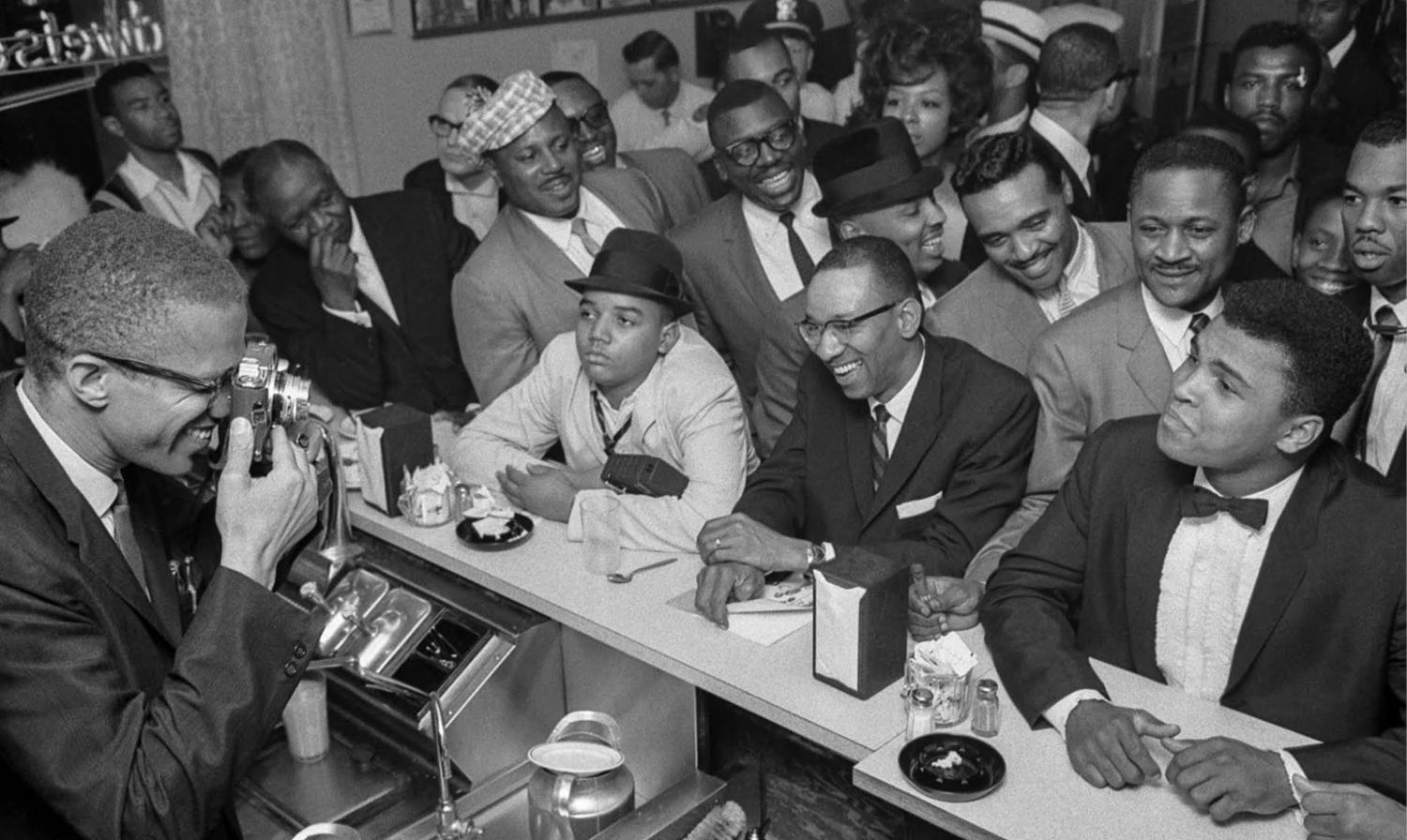Malcolm X photographs Muhammad Ali at the victory party after Ali’s defeat of Sonny Liston, February 25, 1964. Photograph by Bob Gomel, Bob Gomel Photographic Archive. Briscoe Center for American History.